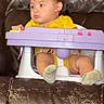 Mateo joined the competition — help win amazing prizes! toddler, baby_seat, yellow_clothing, purple_toy, brown_couch, leather, child, indoor, sitting, infant, footwear, expression, young_child, person, furniture, casual, home, seat, looking_away, wearing_socks