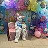 baby, child, easter_bunny, costume, balloons, pastel_colors, easter, holiday, celebration, indoor, decoration, festive, person, floor, chair, banner, cute, smiling, event, holiday_theme
