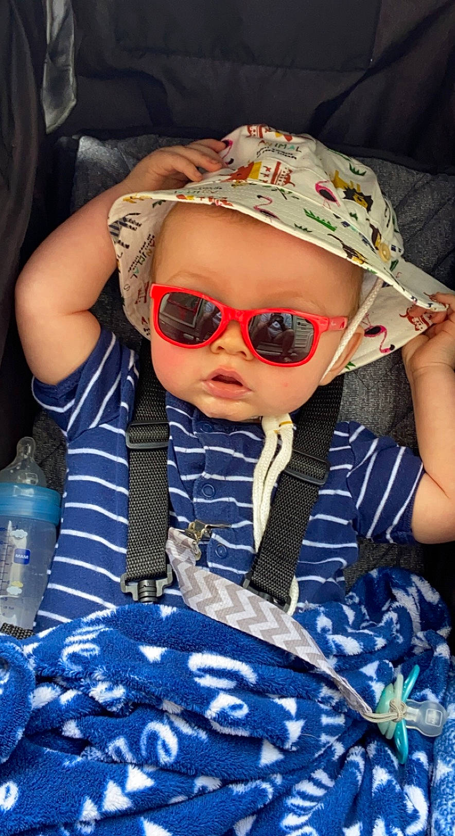 Logan is registered to the contest to win money with this photo: baby_toddler_clothing, blue, bottle, cap, cool, eyewear, face, fun, glasses, goggles, happy, headwear, lip, pattern, person, plastic_bottle, sleeve, street_fashion, sunglasses, toddler