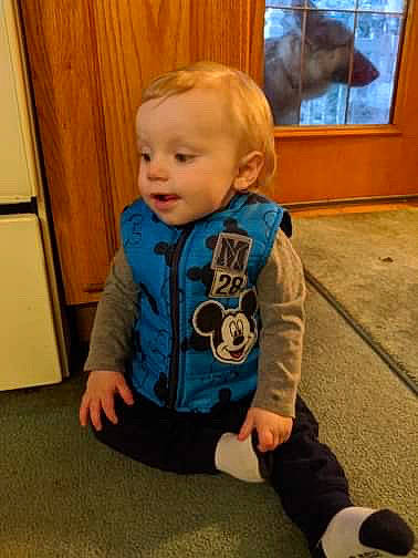 Oakley is registered to the contest to win money with this photo: arm, baby, child, flooring, outerwear, person, play, shoe, sitting, sleeve, toddler, toy
