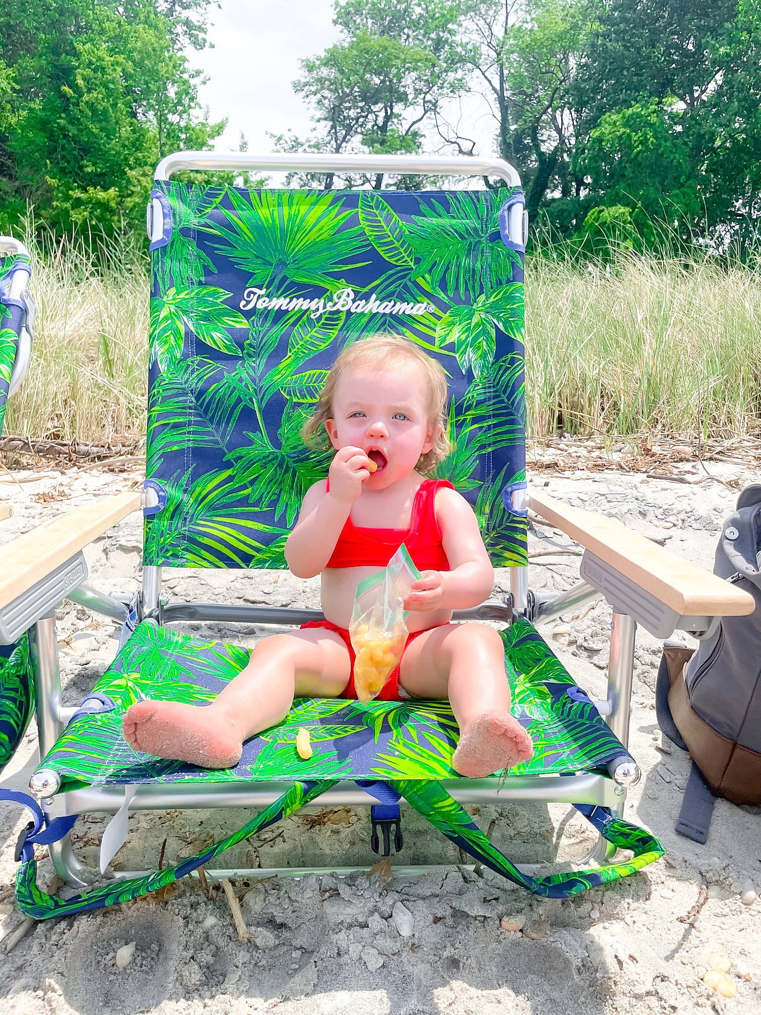 Lucie is registered to the contest to win money with this photo: baby, baby_toddler_clothing, child, fun, grass, green, leisure, outdoor_furniture, outdoor_recreation, people_in_nature, person, plant, play, recreation, shorts, sitting, smile, summer, swimwear, toddler