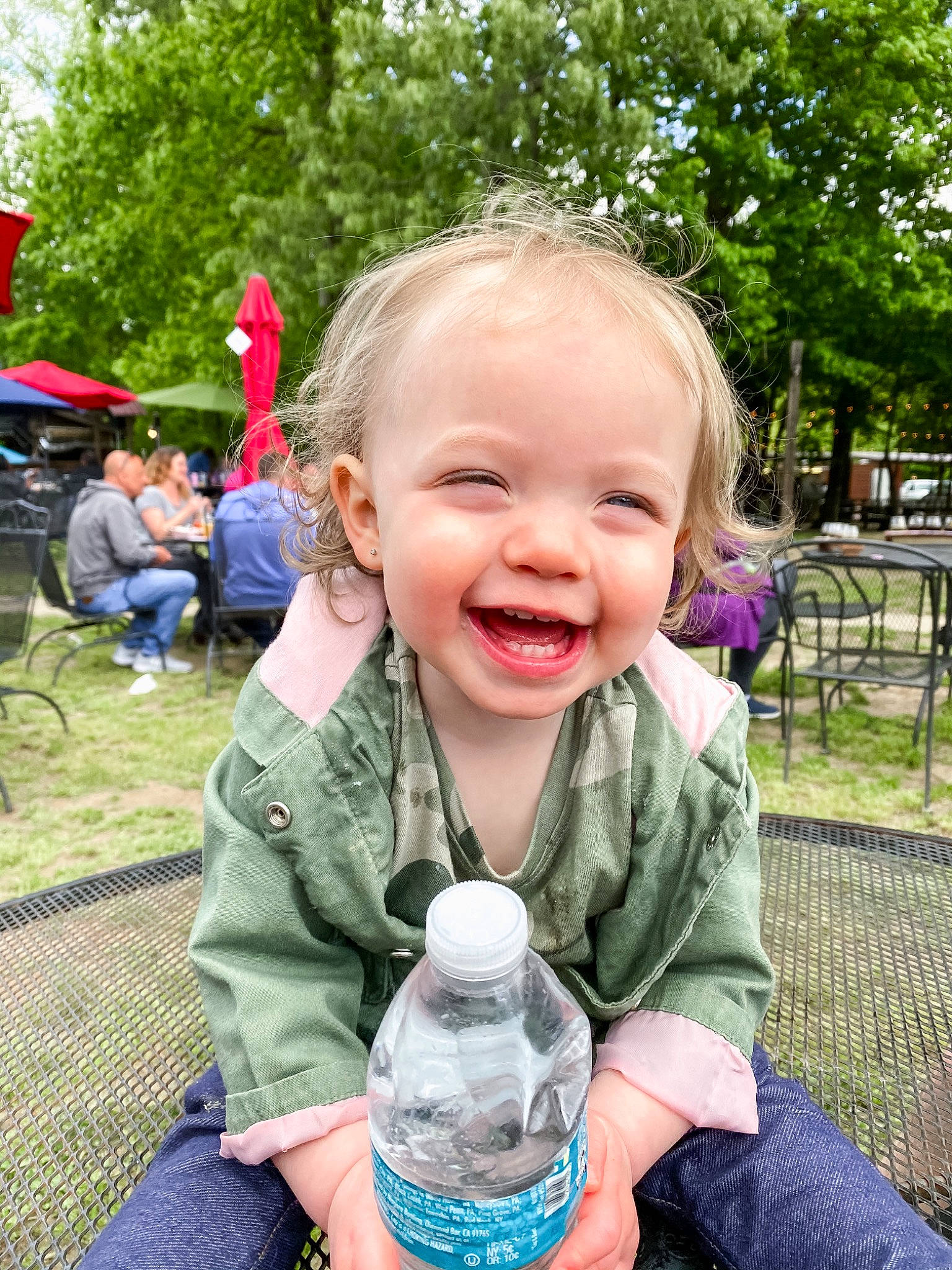 Lucie is registered to the contest to win money with this photo: bottle, chair, child, clothing, drinkware, fun, grass, happy, iris, joy, leisure, people, person, plant, plastic_bottle, recreation, skin, smile, summer, toddler