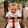 Theo joined the competition — help win amazing prizes! autumn, bench, black, child, clothing, face, fence, hands, happy, leaves, orange, outdoor, park, person, playground, smile, stroller, swing, toddler, white_outfit