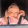 baby, child, pink_hat, knitted_hat, fluffy_jacket, stroller, baby_carrier, blue_eyes, infant, cute, face, portrait, cold_weather_clothing, seat_belt, baby_jacket, baby_clothing, young_child, baby_accessories, outdoor_gear, baby_bundled