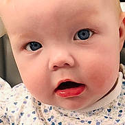 Amber is registered to the contest to win money with this photo: baby, closeup, blue_eyes, blonde_hair, floral_onesie, infant, cute, child, face, expression, portrait, young, skin, mouth_open, curious, sitting, indoors, soft_light, human, head