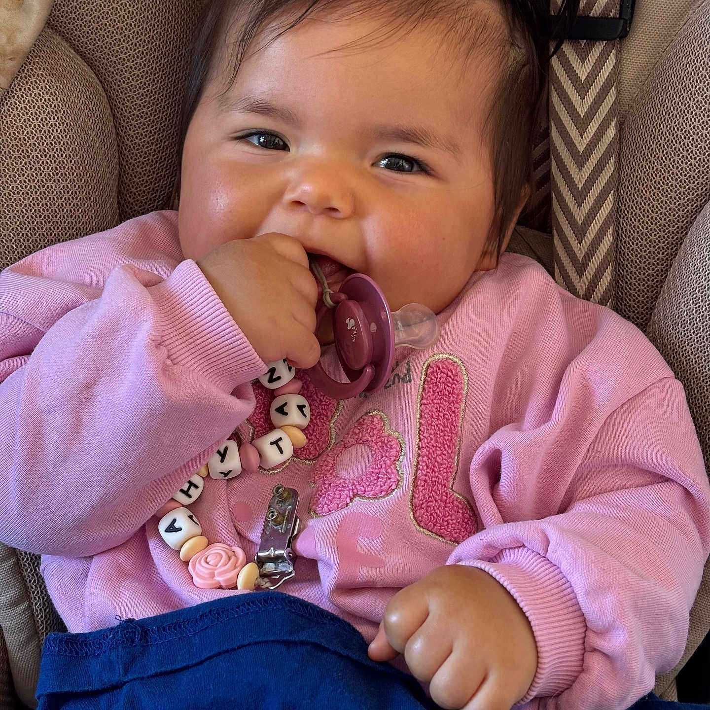 Ahytana a rejoint le concours — aidez-le/la à gagner de superbes lots ! baby, child, pacifier, pink_sweater, blue_pants, car_seat, pigtails, smiling, cute, happy, indoor, closeup, face, hand, toy, accessory, clothing, person, infant, portrait