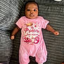 Chavonne is registered to the contest to win money with this photo: baby, baby_bottle_graphic, child, clothing, comfortable, couch, cute, face, furniture, gray_couch, indoors, infant, lying_down, peaceful, pink_onesie, portrait, resting, socks, text_on_clothing, young_child