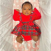Chavonne is registered to the contest to win money with this photo: adorable, baby, bassinet, blanket, child, comfortable, cozy, curly_hair, cute, fashion, indoors, infant, lying_down, plaid, portrait, red_dress, small_fists, soft_texture, star_pattern, white_socks