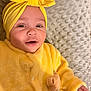 Beyla a rejoint le concours — aidez-le/la à gagner de superbes lots ! baby, child, smile, yellow_clothing, headwrap, blanket, fuzzy, cute, portrait, infant, happy, soft_texture, lying_down, face, hand, indoors, warm_clothing, baby_girl, adorable, cozy