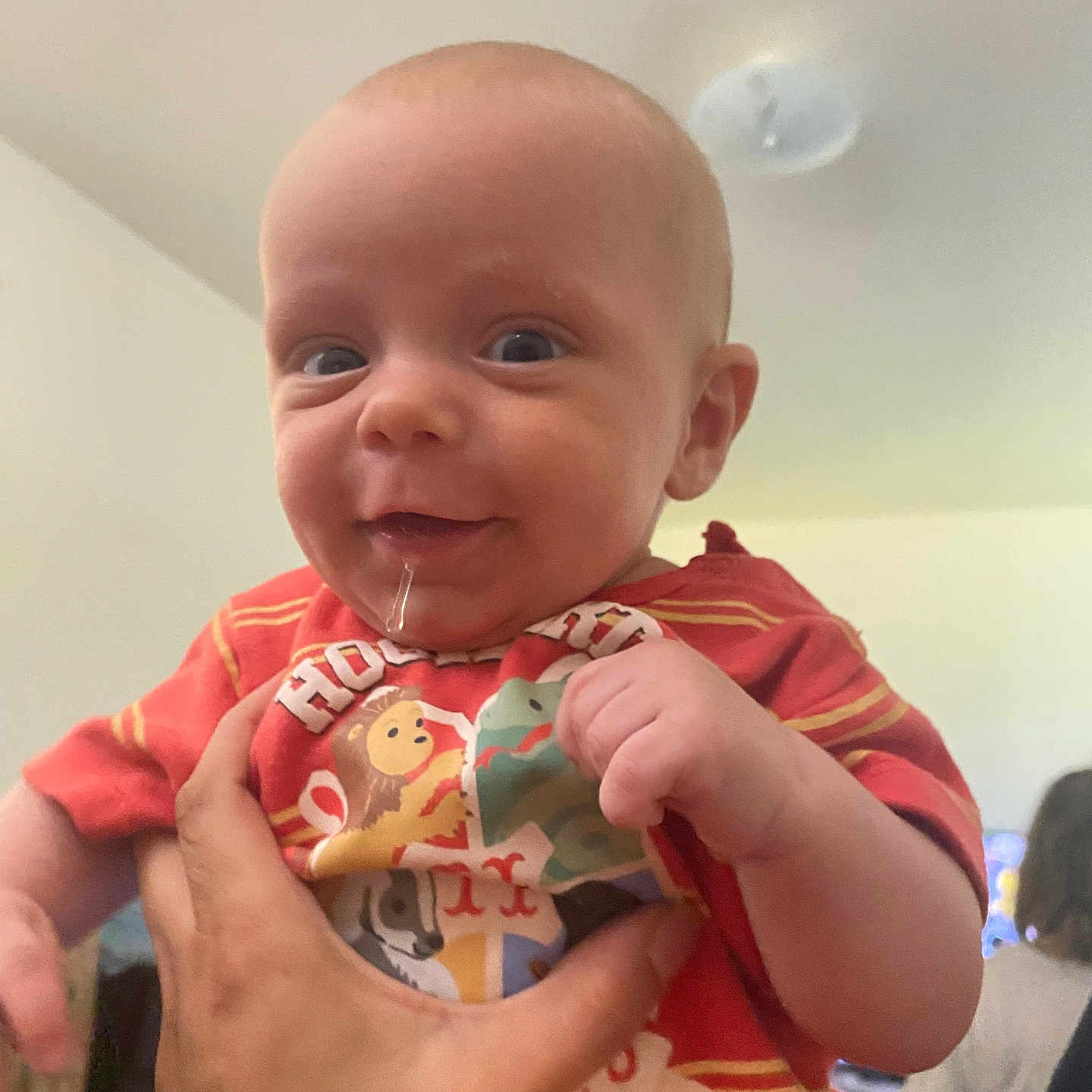 Bennyt is registered to the contest to win money with this photo: animal_print, baby, ceiling_light, child, clothing, cute, drool, face, hand, happy, holding, human, indoor, person, portrait, shirt, skin, smile, tattoo, toddler