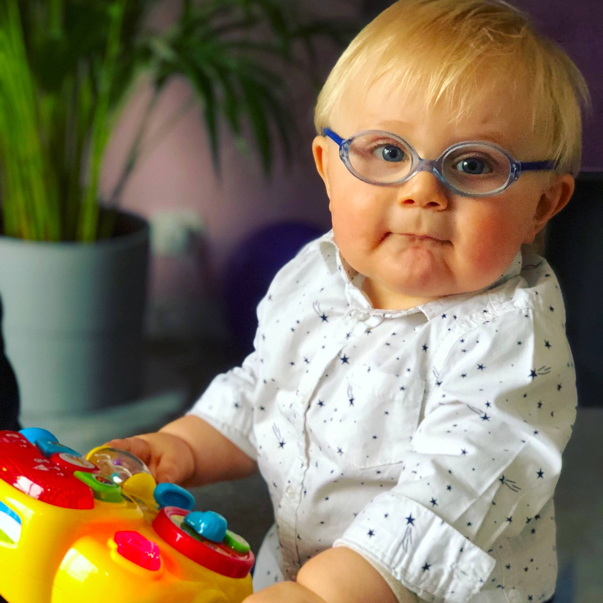 Maë a rejoint le concours — aidez-le/la à gagner de superbes lots ! baby, baby_playing_with_toys, blond, cheek, child, ear, eye, glasses, nose, person, play, sitting, toddler, toy, tummy_time, vision_care