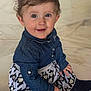 toddler, child, smiling, denim_jacket, dress, patterned_clothing, floor, marble_floor, sitting, happy, cute, face, portrait, indoor, young_child, small_hands, long_sleeves, buttoned_jacket, eyes, hair
