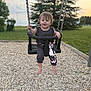 toddler, child, swing, playground, barefoot, grass, trees, sunset, outdoor, happy, smiling, clothing, cartoon_character, play, fun, nature, park, daylight, person, baby