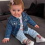 toddler, child, denim_jacket, jeans, shoes, minnie_mouse, bow, hair_accessory, smile, couch, indoor, cute, person, sitting, clothing, footwear, baby, portrait, happy, casual