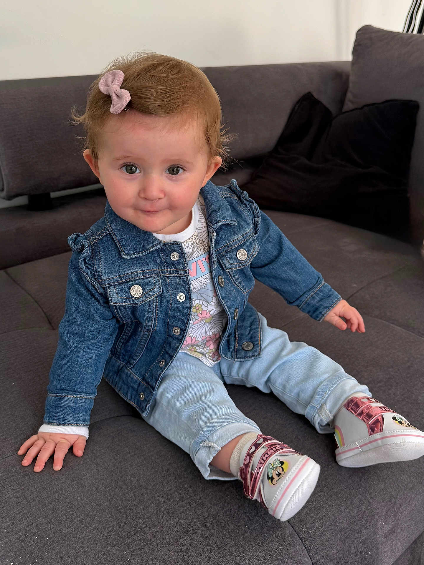 Lola a rejoint le concours — aidez-le/la à gagner de superbes lots ! toddler, child, denim_jacket, jeans, shoes, minnie_mouse, bow, hair_accessory, smile, couch, indoor, cute, person, sitting, clothing, footwear, baby, portrait, happy, casual