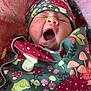 Iris is registered to the contest to win money with this photo: baby, yawning, blanket, hat, mushroom_pattern, infant, sleepy, cozy, pink_background, soft_texture, child, wrapped, cute, face, mouth_open, clothing, newborn, portrait, indoors, resting