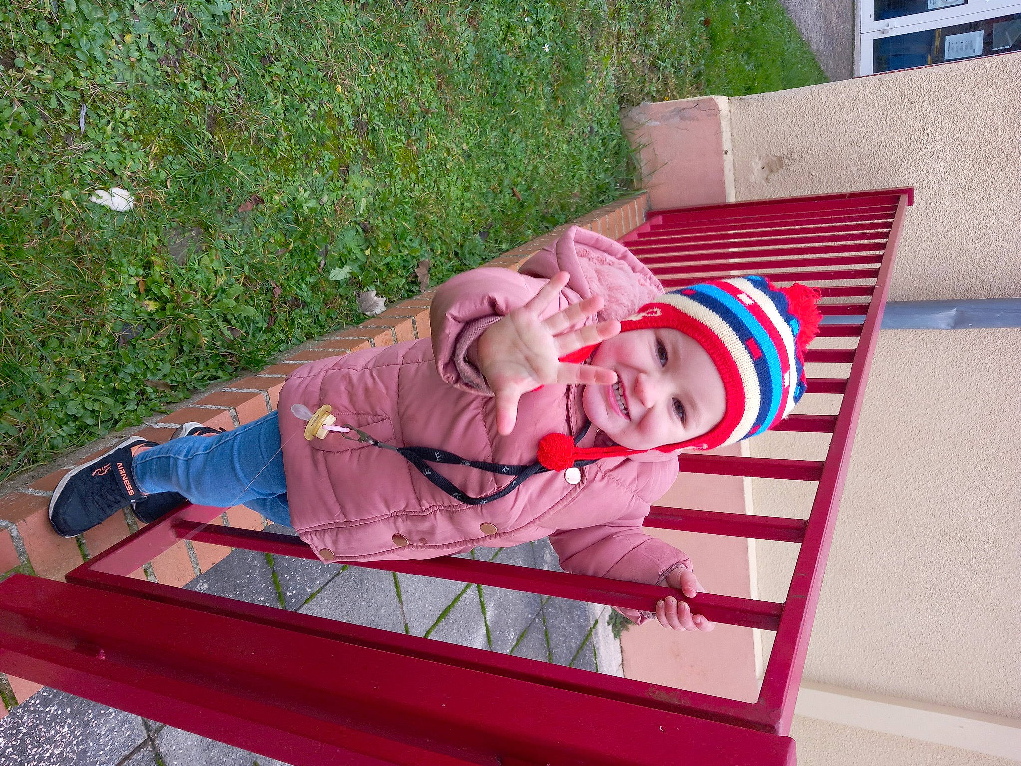 Fanny participe au concours pour gagner de l'argent avec cette photo : baby, baby_products, baby_toddler_clothing, carmine, child, flag_of_the_united_states, grass, headwear, joy, leisure, magenta, outdoor_bench, outdoor_furniture, person, plant, recreation, rectangle, sitting, toddler, wood