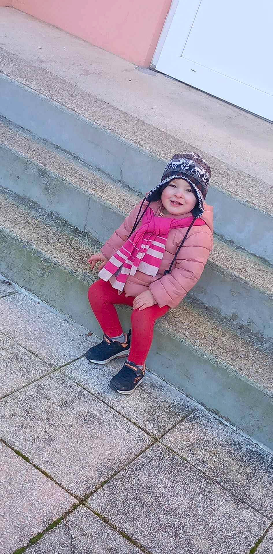 Fanny participe au concours pour gagner de l'argent avec cette photo : asphalt, baby_toddler_clothing, electric_blue, eye, fashion_accessory, flooring, happy, headwear, human_leg, joy, knee, leisure, magenta, pattern, person, pink, road_surface, sitting, sleeve, smile