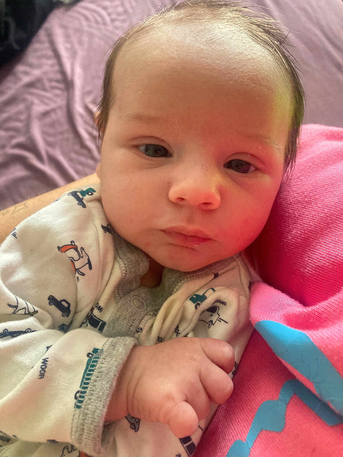 Rhydian is registered to the contest to win money with this photo: adorable, baby, bed, blanket, close_up, eyes, face, family_moment, hair, hand, infant, newborn, onesie, patterned_clothing, pink, portrait, skin, sleepy, small_fingers, soft_light