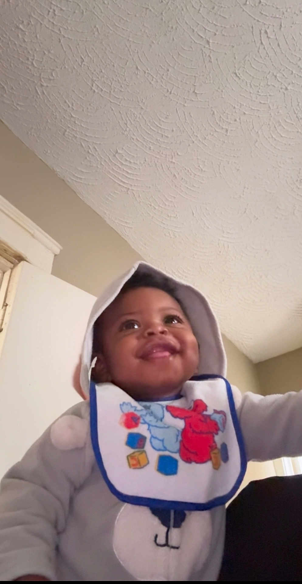 Matthew joined the competition — help win amazing prizes! baby, child, hoodie, bib, smile, indoor, happy, infant, face, clothing, person, cute, portrait, young_child, warm_clothes, expression, closeup, headwear, apparel, home