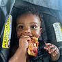 baby, car_seat, child, closeup, curly_hair, cute, eating, face, food, hands, happy, indoor, infant, messy, person, pizza, sauce, seatbelt, smile, young