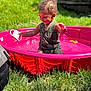 child, clothing, daylight, fence, fun, grass, green, happy, outdoor, person, pink, play, pool, smile, splash, summer, sunlight, toddler, toy, water