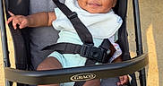 Yaila is registered to the contest to win money with this photo: baby, stroller, smile, bow, child, outdoor, sunlight, happiness, seatbelt, clothing, person, infant, graco, feet, hand, fabric, safety, cute, playful, relaxing