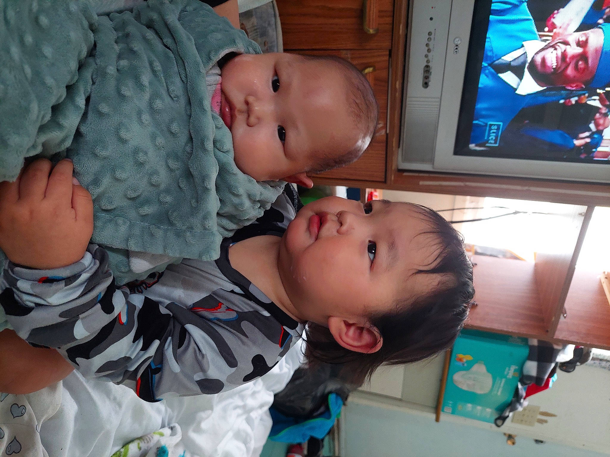 Cora is registered to the contest to win money with this photo: baby, baby_toddler_clothing, cheek, child, comfort, facial_expression, fun, happy, headwear, home_appliance, mouth, nose, organ, output_device, person, product, skin, smile, television, television_set