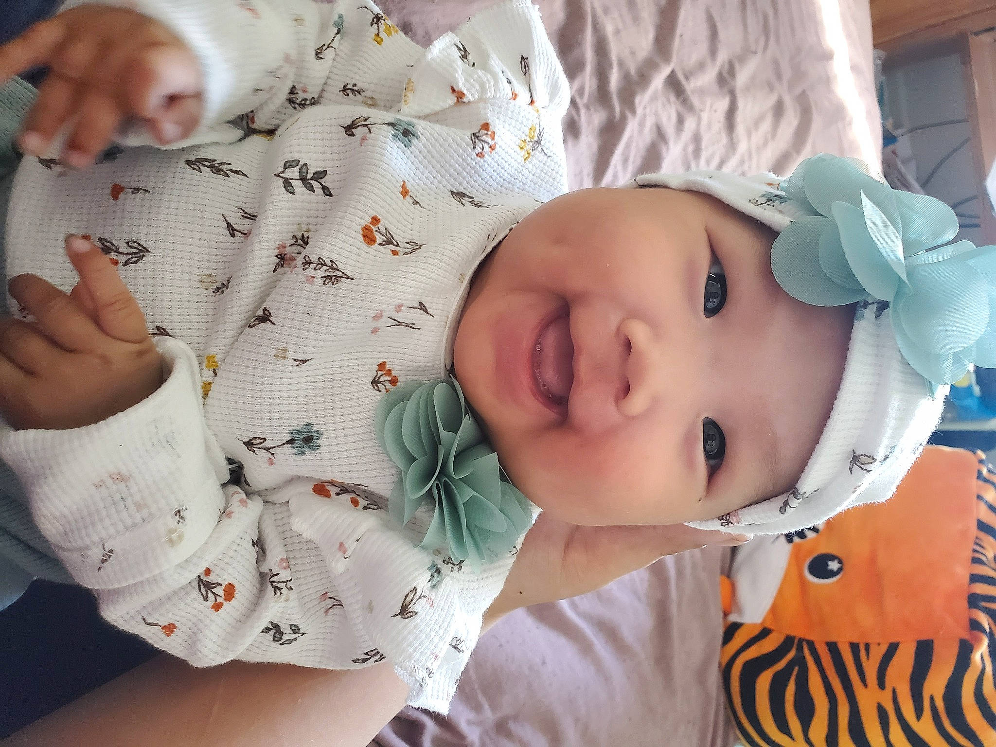 Cora is registered to the contest to win money with this photo: baby, baby_products, baby_toddler_clothing, cheek, child, comfort, design, finger, hand, happy, hat, headwear, human, nail, pattern, person, skin, sleeve, smile, thumb