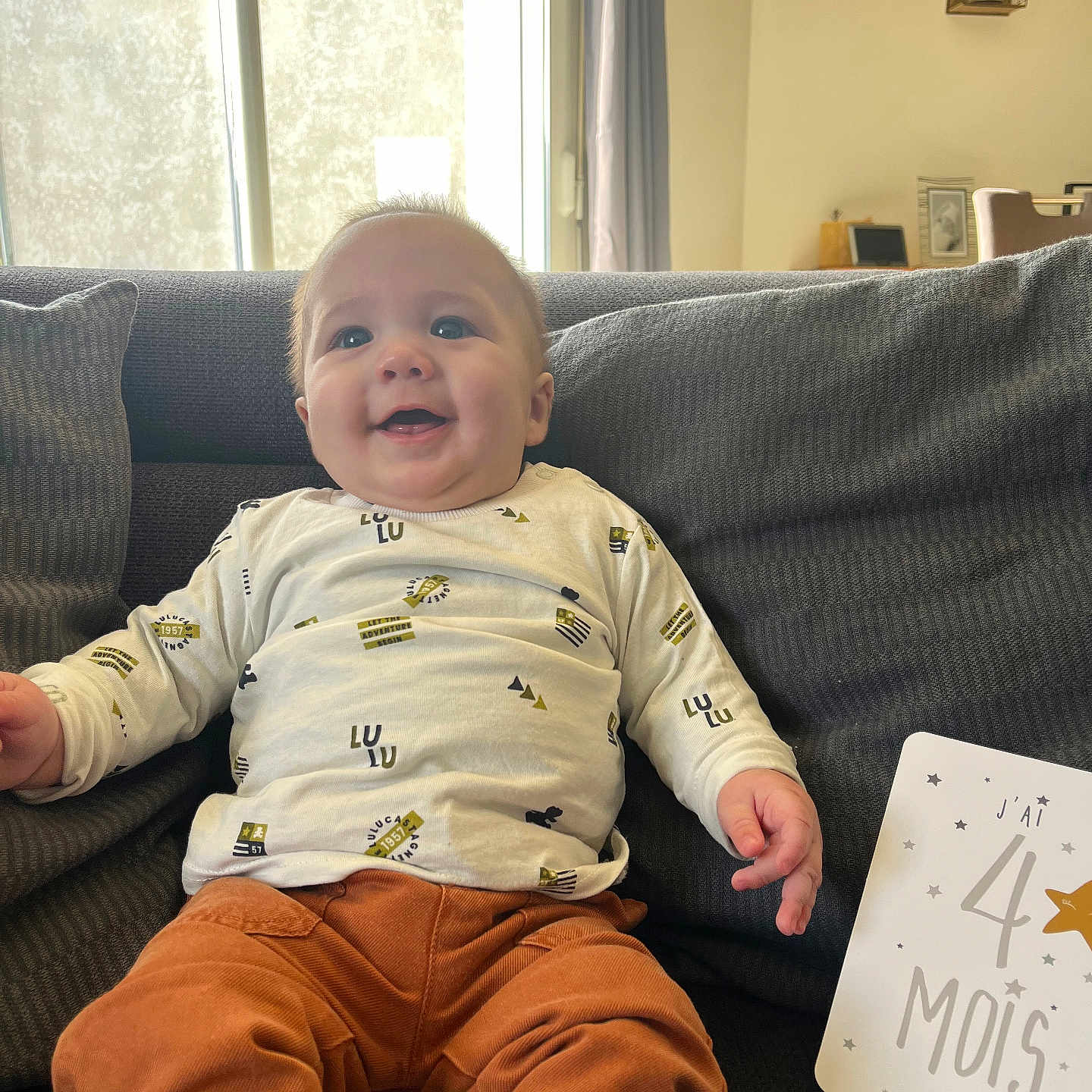 Maëlan a rejoint le concours — aidez-le/la à gagner de superbes lots ! architecture, baby, building, chair, clothing, couch, cushion, face, furniture, happy, head, homedecor, indoors, livingroom, pants, person, photography, portrait, room, sitting