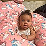 Nova joined the competition — help win amazing prizes! baby, child, infant, curly_hair, bracelet, pacifier, pink_cushion, unicorn_pattern, white_tank_top, indoor, bed, mattress, pillow, cute, portrait, face, eyes, skin, person, adorable