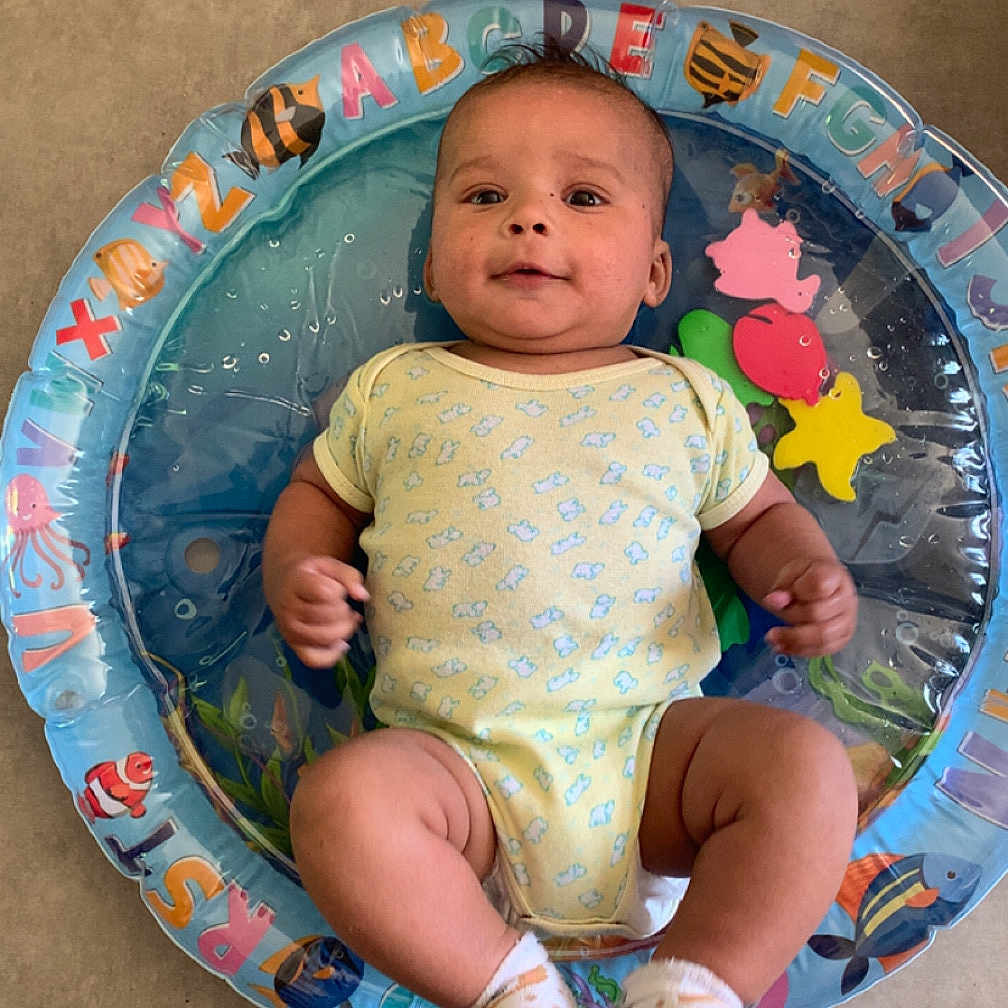 Maël a rejoint le concours — aidez-le/la à gagner de superbes lots ! alphabet, baby, child, colorful, cute, floating, floor, happy, indoor, infant, inflatable_ring, onesie, person, playtime, portrait, sea_creatures, smiling, socks, water_toy, young_child