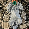 baby, blanket, blue_sleeper, child, comfort, cozy, cute, family, indoor, infant, lying_down, newborn, pacifier, peaceful, plaid, resting, sleeping, soft_texture, wearing_clothes, young