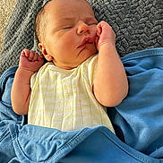 Weston is registered to the contest to win money with this photo: newborn, baby, sleeping, blanket, yellow_clothing, blue_blanket, infant, cozy, peaceful, portrait, closeup, skin, hand, face, head, texture, soft, resting, indoors, cute