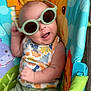 baby, sunglasses, child, colorful, animal_print, seat, playful, smiling, summer, cute, infant, clothing, green_shorts, tank_top, indoor, joyful, fun, accessory, portrait, happy