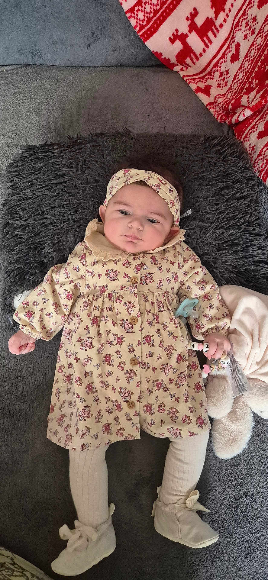 Olivia participe au concours pour gagner de l'argent avec cette photo : baby, infant, child, floral_dress, headband, pillow, blanket, soft_toy, cozy, cute, lying_down, indoors, white_booties, patterned_clothing, pink, beige, warm, portrait, small_hand, expression