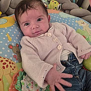 Olivia a rejoint le concours — aidez-le/la à gagner de superbes lots ! baby, infant, child, cute, smiling, hand, cushion, colorful, toy, plush, jeans, knit_sweater, indoor, portrait, face, curly_hair, comfort, closeup, lying_down, playful