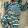 baby, sleeping, pacifier, blue_clothing, striped_pants, blanket, soft_texture, infant, cozy, child, cute, resting, indoors, newborn, comfort, white_socks, nursery, peaceful, portrait, lying_down