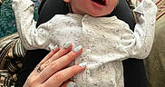 Maximillian joined the competition — help win amazing prizes! baby, carpet, cozy, cute, elephant_pattern, family, hand, happy, indoor, infant, lap, nail_art, newborn, onesie, patterned_rug, person, resting, sleeping, smiling, tenderness