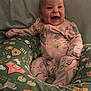 baby, child, smiling, onesie, pillow, cushion, animal_print, farm_theme, indoor, happy, person, infant, cute, comfortable, seated, face, head, expression, clothing, soft