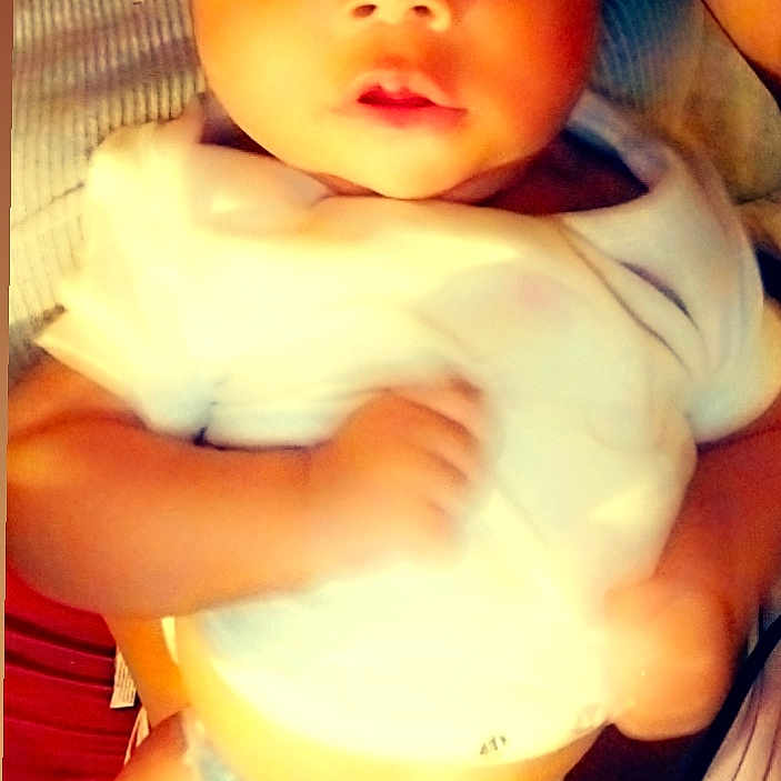 Kasani is registered to the contest to win money with this photo: baby, child, closeup, cute, diaper, expression, eyes, face, hand, holding, human, indoors, infant, person, portrait, skin, soft_focus, warm_light, white_shirt, young