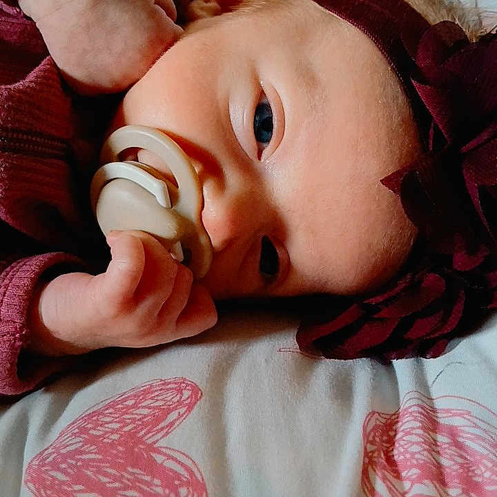 Chloey is registered to the contest to win money with this photo: baby, bed, blanket, closeup, cuddle, cute, face, hand, headband, heart_pattern, infant, lying_down, pacifier, person, resting, skin, sleepwear, soft_lighting, warm_colors, young_child