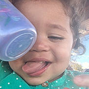 Xariah joined the competition — help win amazing prizes! toddler, child, curly_hair, tongue_out, green_shirt, polka_dots, cup, hand, outdoor, sky, playful, close_up, smile, buttoned_shirt, face, person, happy, daylight, expression, young_child