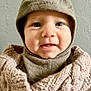 apparel, baby, blue_eyes, button, child, closeup, cozy, cute, face, happy, hat, headwear, indoor, infant, knitted_clothing, person, portrait, smile, texture, warm_clothing