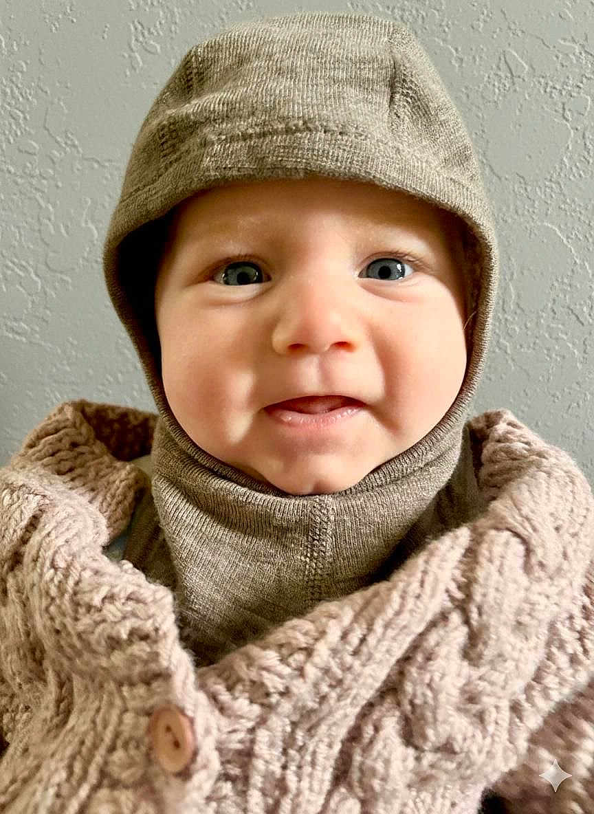 Joé participe au concours pour gagner de l'argent avec cette photo : apparel, baby, blue_eyes, button, child, closeup, cozy, cute, face, happy, hat, headwear, indoor, infant, knitted_clothing, person, portrait, smile, texture, warm_clothing
