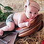 baby, headband, leather, saddle, straw, stone_wall, plant, indoor, curious, child, diaper, pink, face, skin, resting, closeup, person, infant, cute, portrait