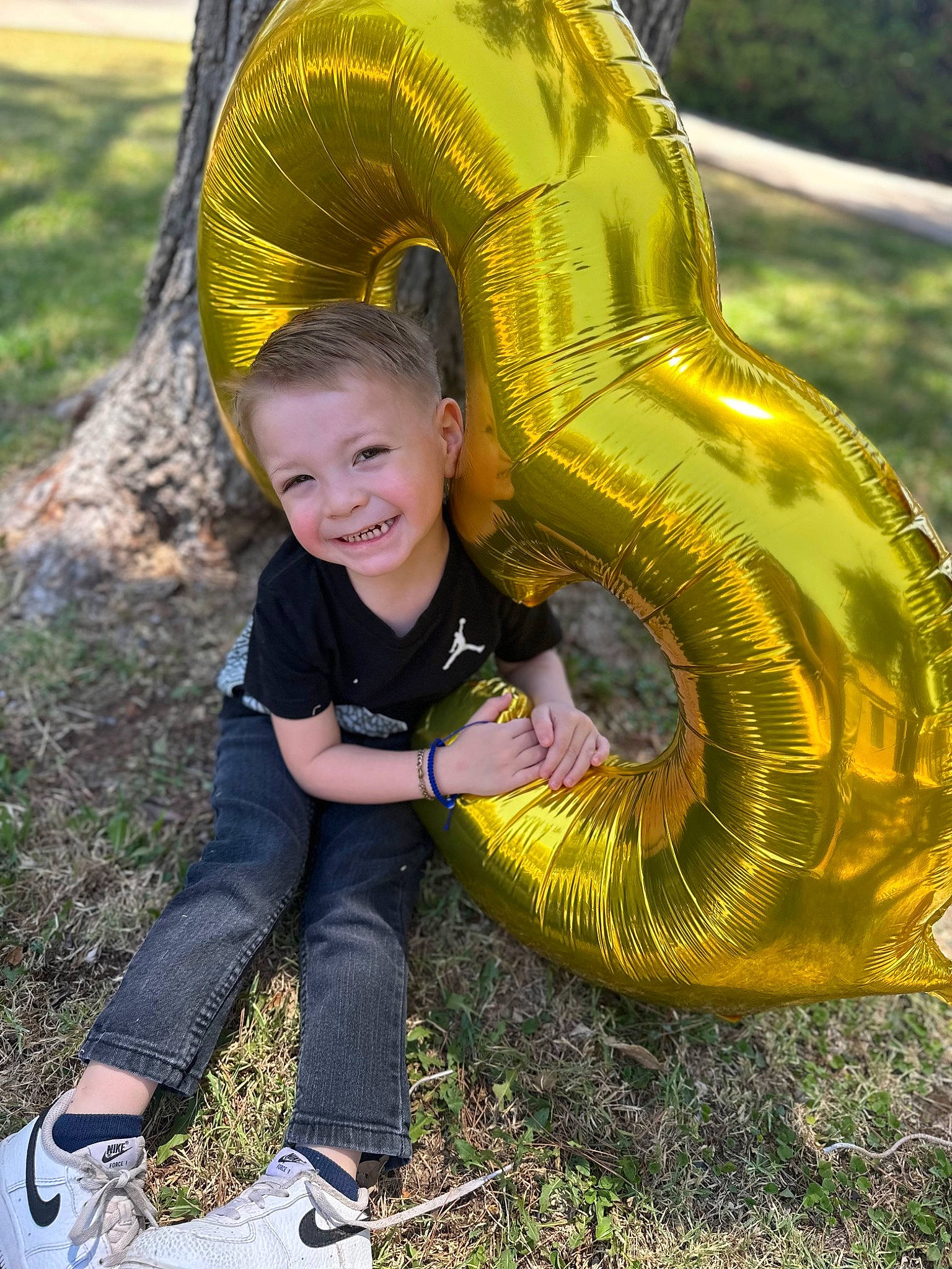 Gabriel is registered to the contest to win money with this photo: automotive_tire, botany, child, eye, facial_expression, fun, grass, happy, joy, leisure, people_in_nature, person, photograph, plant, play, recreation, sitting, smile, t_shirt, toddler