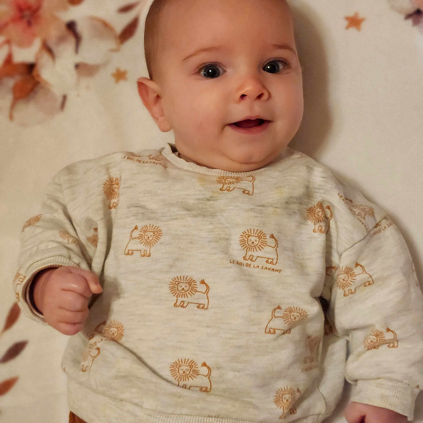 Romain a rejoint le concours — aidez-le/la à gagner de superbes lots ! baby, blanket, child, clothing, cute, eyes, face, floral, hand, happy, head, indoors, infant, lion_pattern, lying_down, person, portrait, skin, smiling, sweater