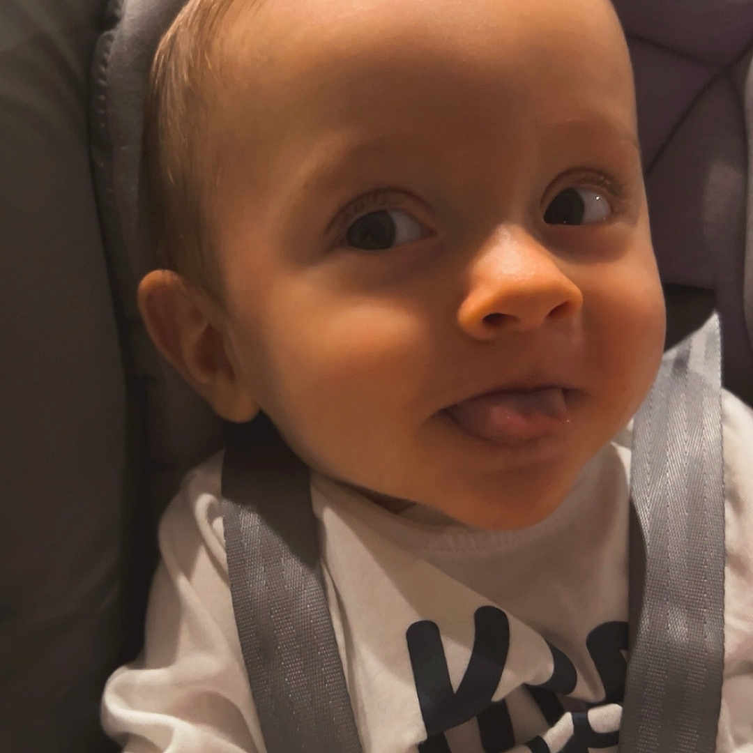 Lilio Mocrette participe au concours pour gagner de l'argent avec cette photo : baby, car_seat, child, closeup, clothing, curious, cute, expression, face, head, indoor, infant, person, playful, seat, smile, straps, tongue_out, white_shirt, young_child