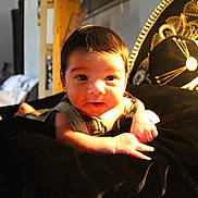 Josiah joined the competition — help win amazing prizes! baby, infant, face, hands, colorful_clothing, black_fabric, light, sunlight, indoor, portrait, cute, curious, soft_focus, room, furniture, skin, person, newborn, lying_down, warm_lighting